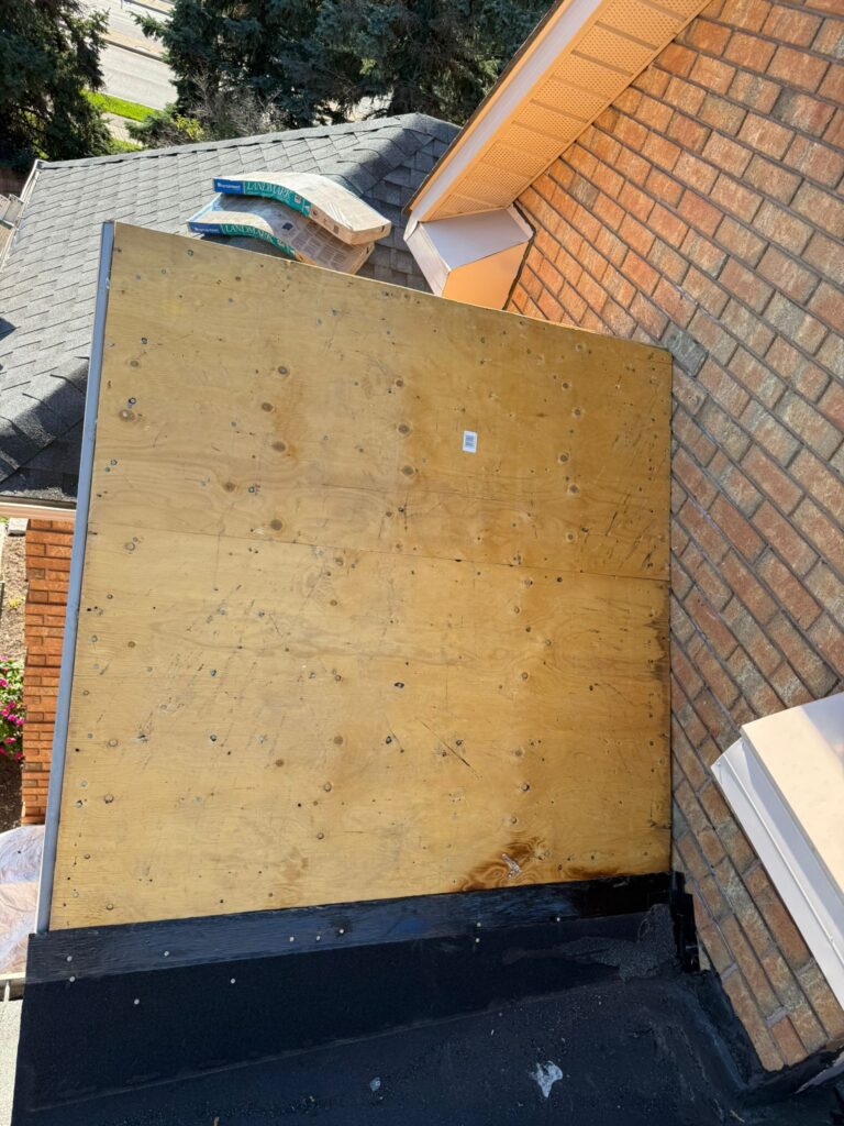 damaged roof section with exposed plywood before roof repair in Toronto