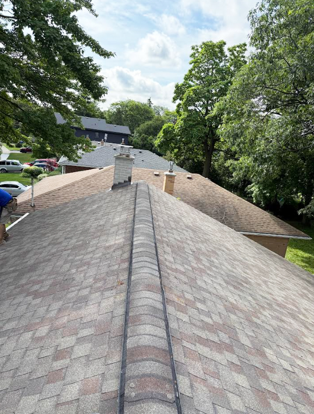 Completed asphalt shingle roof leak repair with restored ridge shingles in Markham.