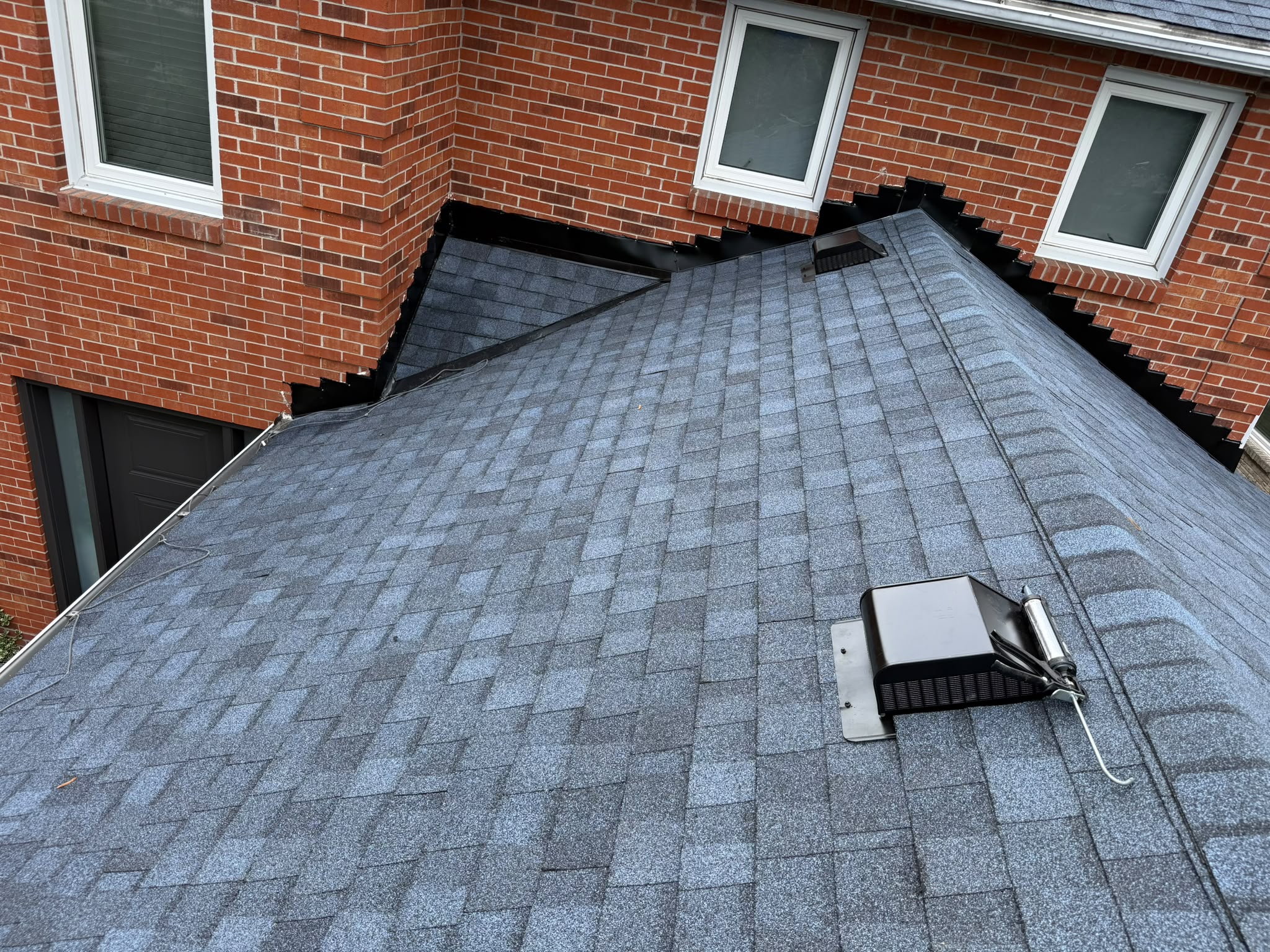 Completed asphalt shingle roof repair with new flashing