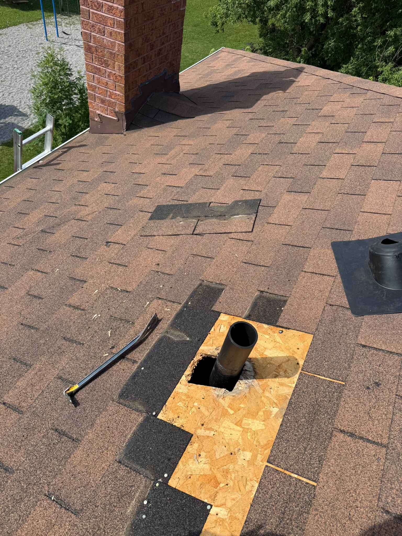 Roof damage repair with exposed roof decking and shingles in Toronto