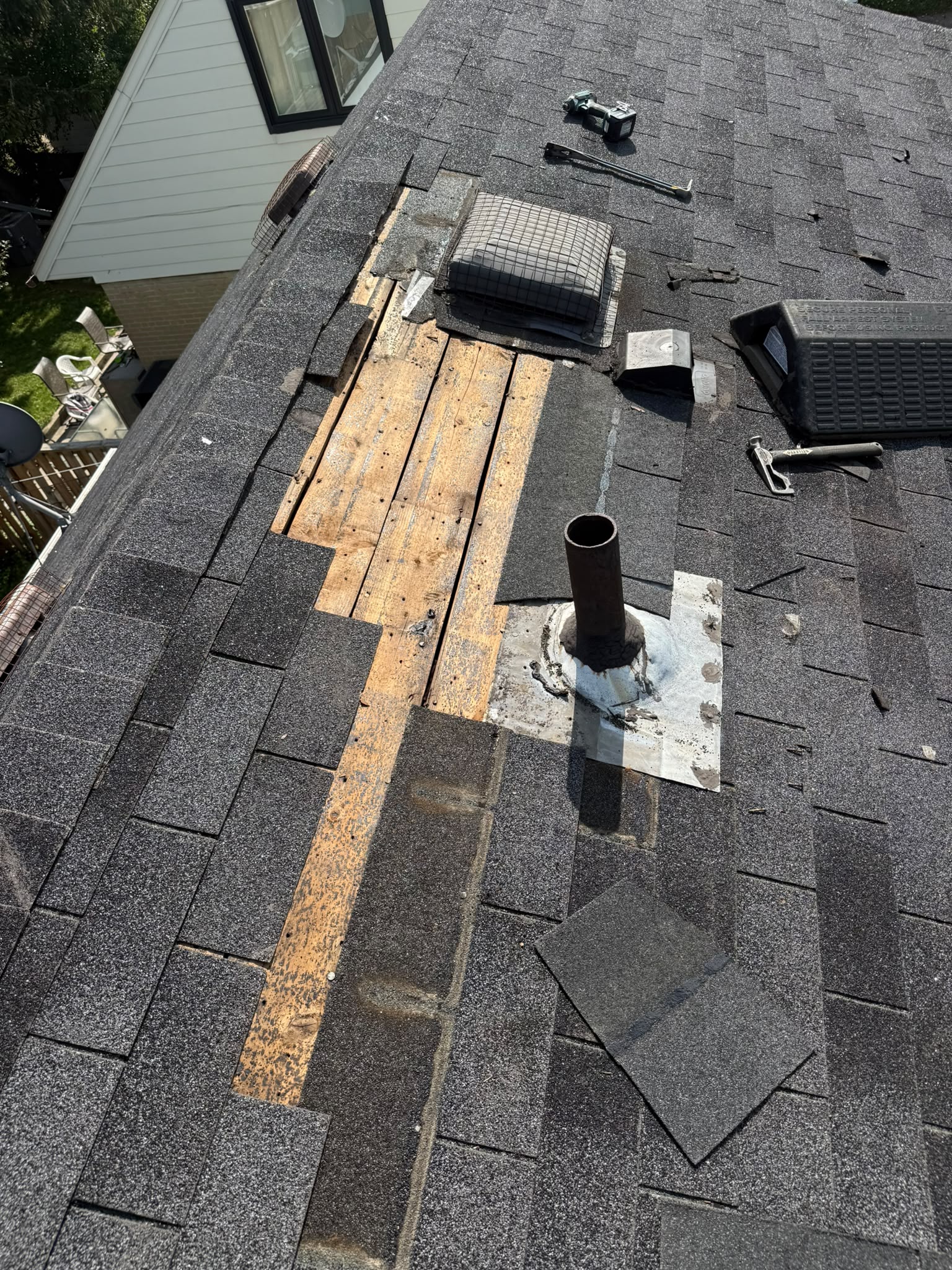 Roof deck repair in progress after removing damaged shingles