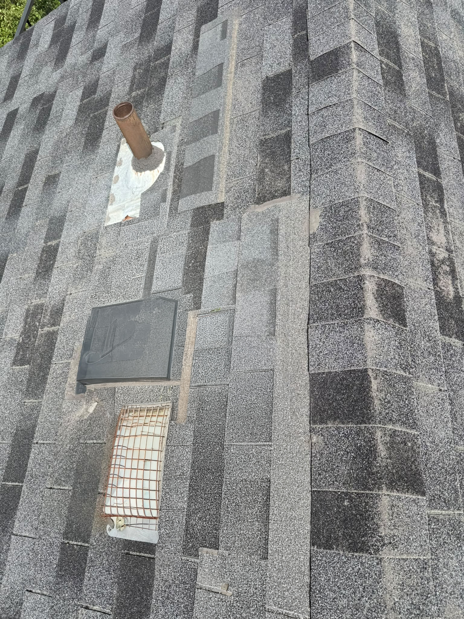 Completed shingle repair around roof vents and pipe flashing