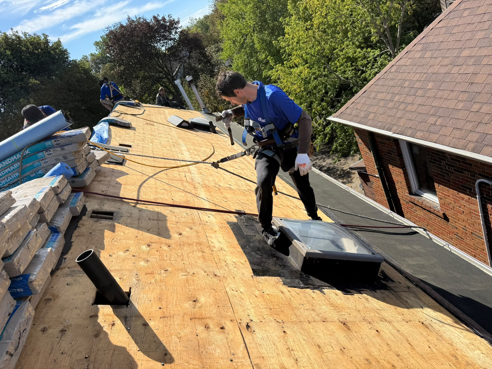 Roof repair Aurora – roofer working on exposed plywood roof decking